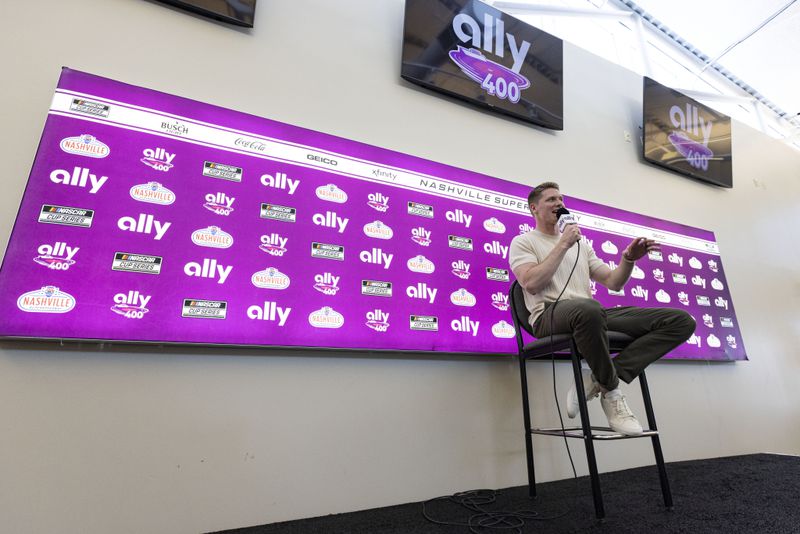 Two-time Indianapolis 500 winner Josef Newgarden speaks to reporters before a NASCAR Cup Series auto race, Sunday, June 30, 2024, in Gladeville, Tenn. (AP Photo/Wade Payne)