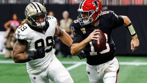 Atlanta Falcons quarterback Kirk Cousins (18) runs out of the pocket against New Orleans Saints defensive end Chase Young (99) during the second half of an NFL football game, Sunday, Sept. 29, 2024, in Atlanta. (AP Photo/Butch Dill)