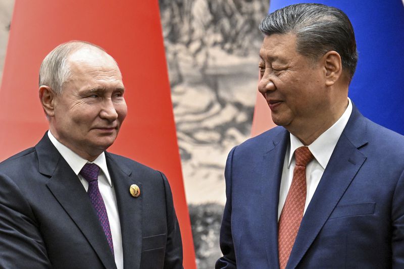 FILE - Chinese President Xi Jinping, right, and Russian President Vladimir Putin look toward each other as they shake hands prior to their talks in Beijing, China, Thursday, May 16, 2024. China appears to be keeping its distance as Russia and North Korea move closer to each other with a new defense pact that could tilt the balance of power between the three authoritarian states. (Sergei Bobylev, Sputnik, Kremlin Pool Photo via AP, File)