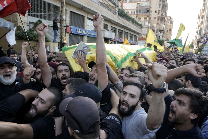 Hezbollah members carry the coffins of their comrades who were killed in Friday's Israeli strike, during their funeral procession in the southern suburb of Beirut, Saturday, Sept. 21, 2024. (AP Photo/Bilal Hussein)