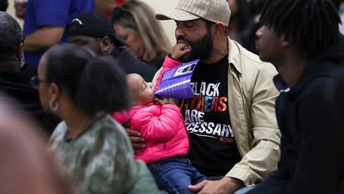 Milton Shabazz with his daughter, Zora. Shabazz is wearing a "Black Fathers are Necessary" shirt while attending a March 13 "Peace Not Guns" community Healing Town Hall meeting at Imhotep Institute Charter High School in Philadelphia. (Heather Khalifa/The Philadelphia Inquirer/TNS)