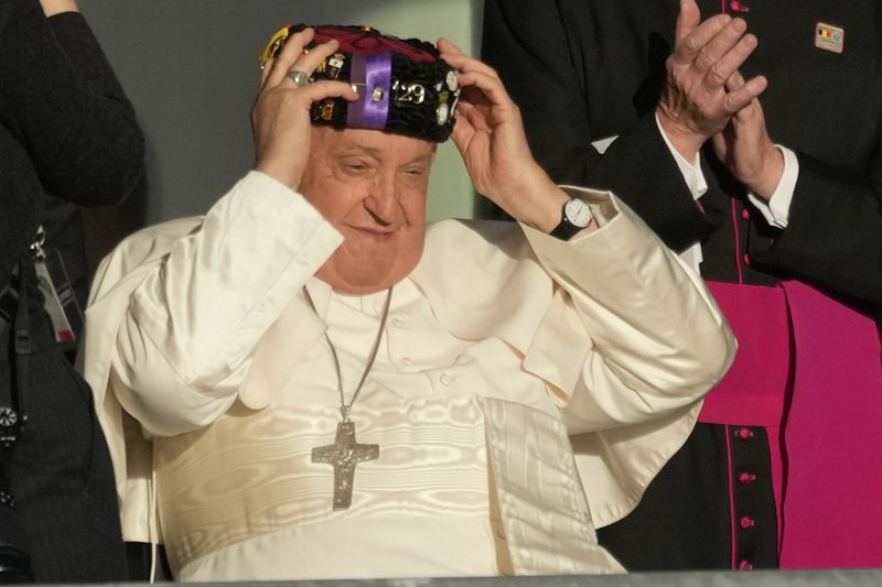 Pope Francis wears a traditional hat at the end of his meeting with students of the Louvain Catholic University in Ottignies-Louvain-la-Neuve, Belgium, Saturday, Sept. 28, 2024. (AP Photo/Andrew Medichini)