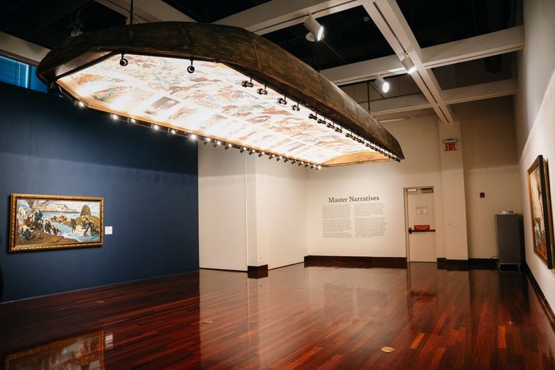 Spelman College Museum of Fine Art showcased Harmonia Rosales' Master Narratives exhibit in 2023. The painting on the blue wall, "The Migration of the Gods," is shown facing towards the Atlantic. (Olivia Bowdoin for the Atlanta Journal-Constitution).  