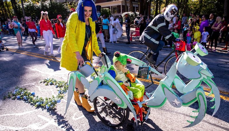 Lindsay Wilkinson operates the praying mantis carrying her son Miles Wilkinson, 8, in the annual Little Five Points Halloween Parade on Sunday, Oct 23, 2022.  (Jenni Girtman for The Atlanta Journal-Constitution)