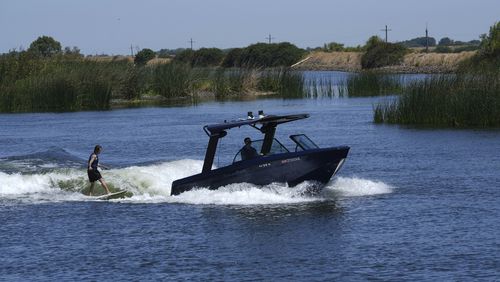 Grant Jeide wake surfs behind an electric sports boat made by California-based Arc Boats on the Sacramento-San Joaquin Delta near Bethel Island, Calif. on Wednesday, July 31, 2024. (AP Photo/Terry Chea)