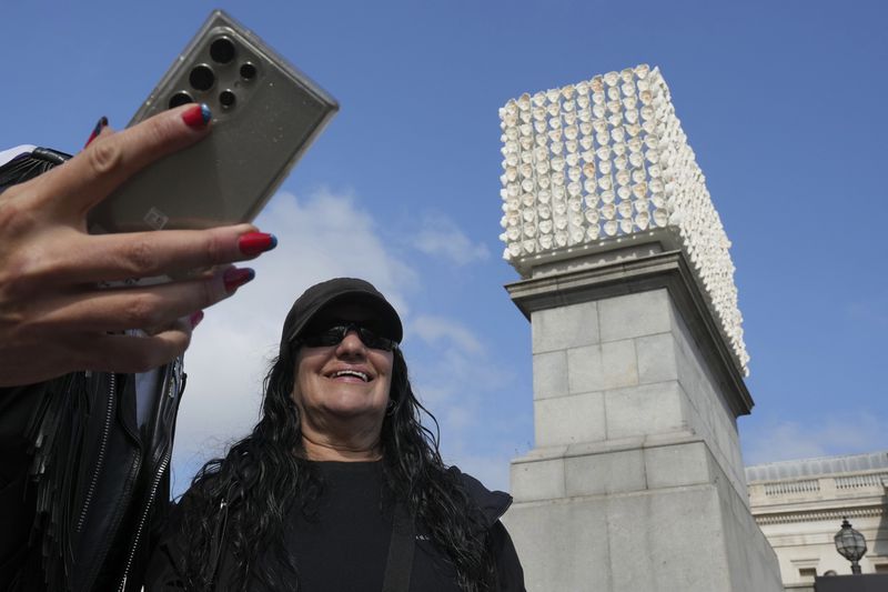 Mexican artist Teresa Margolles poses in front of her artwork "Mil Veces un Instante (A Thousand Times in an Instant)" for the Fourth Plinth, marking 25 years of the ground-breaking commissioning programme for public art at Trafalgar Square, in London, Wednesday, Sept. 18, 2024. (AP Photo/Kin Cheung)