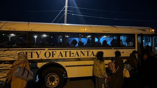 Women and children who were staying in a crowded city of Atlanta warming center at Central Park lined up to take a city bus to an overflow warming center opened nearby on Jan. 16, 2024. The frigid temperatures led more people to see a way out of the cold. Matt Kempner / AJC