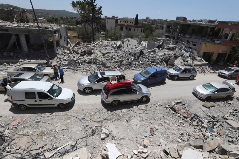 FILE - People inspect their destroyed houses that were hit by an Israeli airstrike, in Aita al-Shaab village, south Lebanon, June 29, 2024. (AP Photo/Mohammed Zaatari, File)