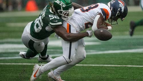 New York Jets linebacker Quincy Williams (56) knocks the ball loose for a fumble by Denver Broncos running back Tyler Badie (28) during the first quarter of an NFL football game, Sunday, Sept. 29, 2024, in East Rutherford, N.J. (AP Photo/Bryan Woolston)