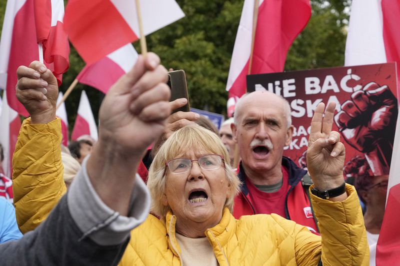 Backers of the right-wing opposition party Law and Justice take part in a protest ally of a few thousand people against the policies of Prime Minister Donald Tusk's Cabinet before the Ministry of Justice, in Warsaw, Poland, Saturday Sept. 14, 2024. (AP Photo/Czarek Sokolowski)