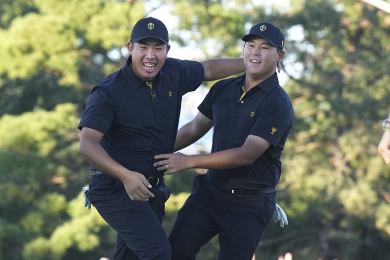 International team member Si Woo Kim of South Korea, celebrates with partner International team member Byeong Hun An of South Korea, after sinking the winning putt on the 18th hole during second round foursome match at the Presidents Cup golf tournament at Royal Montreal Golf Club, Friday, September 27, 2024 in Montreal. (Nathan Denette/The Canadian Press via AP)