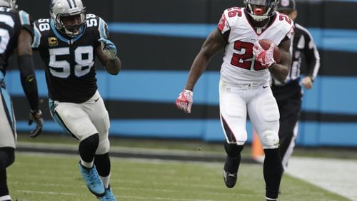 Falcons’ Tevin Coleman runs past the Panthers’ Thomas Davis in the second half of an NFL football game in Charlotte, N.C., Saturday, Dec. 24, 2016. (AP Photo/Bob Leverone)