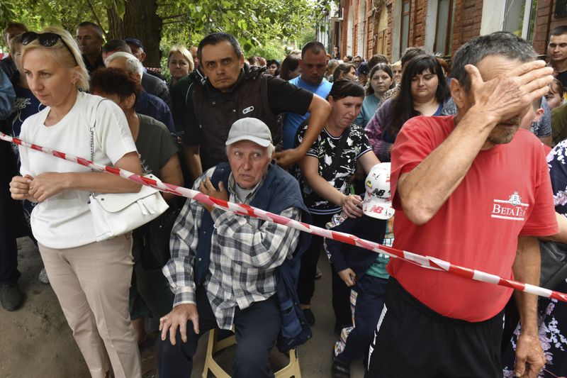 People evacuated from a fighting between Russian and Ukrainian forces queue to receive humanitarian aid at a distribution center in Kursk, Russia, Monday, Aug. 12, 2024. (AP Photo)