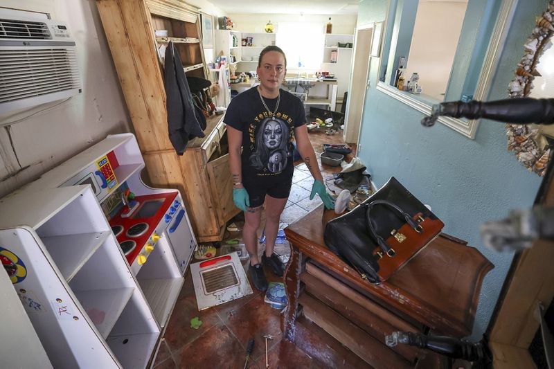 Amanda Normand cleans up the home of Aiden Bowles who died in the home during flooding from Hurricane Helene on Wednesday, Oct. 2, 2024, in Indian Rocks Beach, Fla. (AP Photo/Mike Carlson)