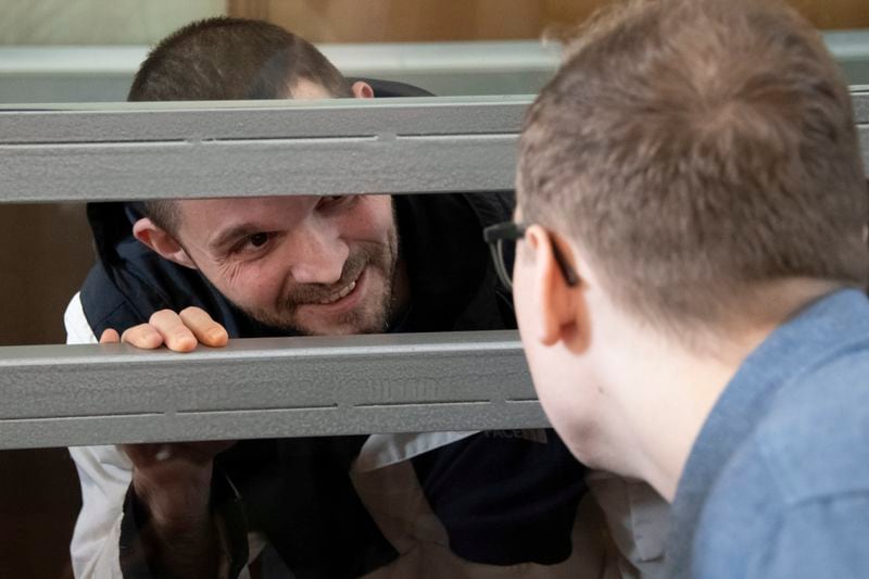 U.S. Army Staff Sgt. Gordon Black talks with his lawyer sitting in a glass cage in courtroom in Vladivostok, Russia, on Wednesday, June 19, 2024. Black is on trial on charges of theft and threatening murder in a dispute with a Russian woman. Russian state media reported that he denied the allegation of threatening murder but "partially" admitted to theft. (AP Photo)