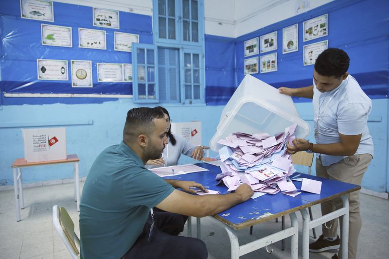 Election officials open a ballot box to count votes after the presidential elections, in the capital Tunis, Tunisia, Sunday, Oct. 6, 2024. (AP Photo/Anis Mili)