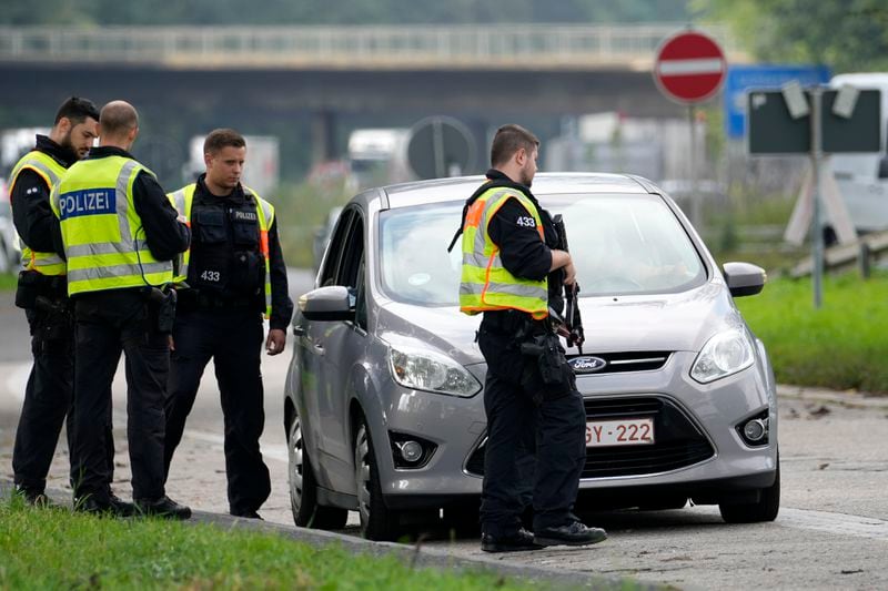 German police check the details of a driver of a car near the border to Belgium in Aachen, Germany, Monday, Sept. 16, 2024, as Germany begins carrying out checks at all its land borders. (AP Photo/Martin Meissner)