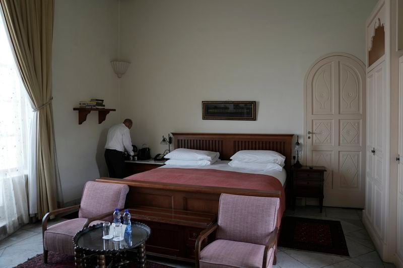 A worker readies a guest room at the American Colony Hotel in east Jerusalem, Sunday, Aug. 18, 2024. As Israel’s economy is suffering from the nearly 11-month war with Hamas, Jerusalem’s iconic American Colony hotel has had to lay off workers and are mulling pay cuts, said Jeremy Berkovitz, the official representative of the owners. (AP Photo/Mahmoud Illean)