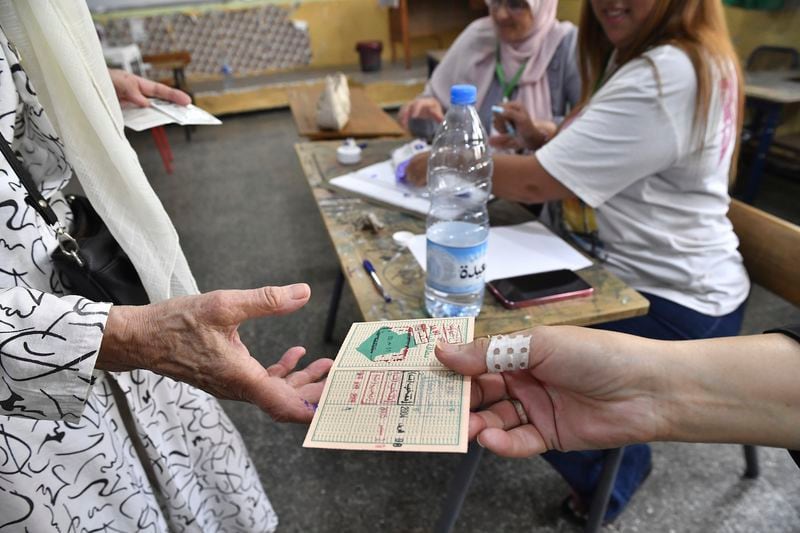 A voter prepares to cast her ballot inside a polling station during the presidential elections, Saturday, Sept. 7, 2024, in Algiers, Algeria. (AP Photo/Fateh Guidoum)