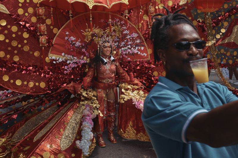 A man takes a selfie with a reveler during the West Indian Day Parade on Monday, Sept. 2, 2024, in the Brooklyn borough of New York. (AP Photo/Andres Kudacki)