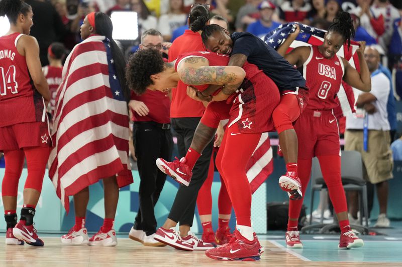 United States' Brittney Griner (15) and United States' Chelsea Gray (8) celebrate after a women's gold medal basketball game at Bercy Arena at the 2024 Summer Olympics, Sunday, Aug. 11, 2024, in Paris, France. (AP Photo/Mark J. Terrill)