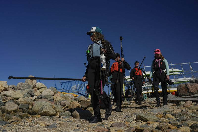 Erin Greene, left, owner of Sup North, leads a tour group down to the shoreline, Thursday, Aug. 8, 2024, in Churchill, Manitoba. (AP Photo/Joshua A. Bickel)