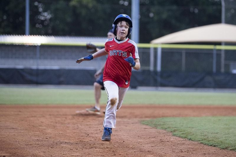 Ethan Lipman, son of Andy Lipman, runs the bases during practice at the Morgan Falls Athletic Fields in Sandy Springs. ALYSSA POINTER / ALYSSA.POINTER@AJC.COM