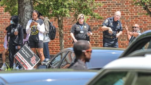 Police officials gather outside of Druid Hills High School after an armed suspect was reported in the area Thursday morning. The suspect, a student at the school, was arrested just before 4 p.m.