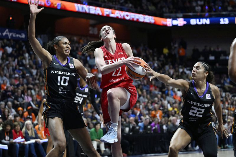 Indiana Fever guard Caitlin Clark (22) is goes to the basket as Connecticut Sun forward Olivia Nelson-Ododa (10) and guard Veronica Burton (22) defend during the first half in Game 2 of a first-round WNBA basketball playoff series, Wednesday, Sept. 25, 2024, in Uncasville, Conn. (AP Photo/Jessica Hill)