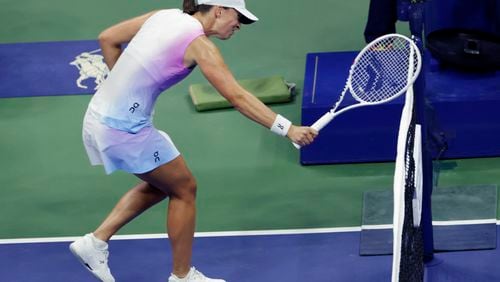 Iga Świątek, of Poland hits the net with her racquet after losing a point to Jessica Pegula, of the United States during the quarterfinals of the U.S. Open tennis championships, Wednesday, Sept. 4, 2024, in New York. (AP Photo/Adam Hunger)