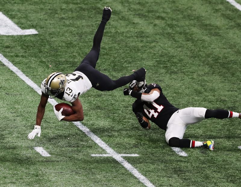 Saints wide receiver Michael Thomas picks up yardage on a catch and is sent flying by Atlanta Falcons safety Sharrod Neasman during the fourth quarter Sunday, Dec. 6, 2020, at Mercedes-Benz Stadium in Atlanta. (Curtis Compton / Curtis.Compton@ajc.com)