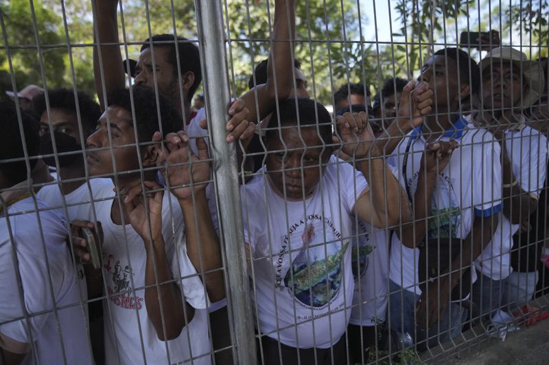 People wait for Pope Francis' arrival at Dili Presidente Nicolau Lobato International Airport in Dili, East Timor, Monday, Sept. 9, 2024. (AP Photo/Dita Alangkara)