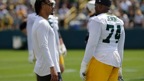 Green Bay Packers' Jordan Love, left, and Elgton Jenkins, right, talk during NFL football training camp Monday, July 22, 2024, in Green Bay, Wis. (AP Photo/Mike Roemer)