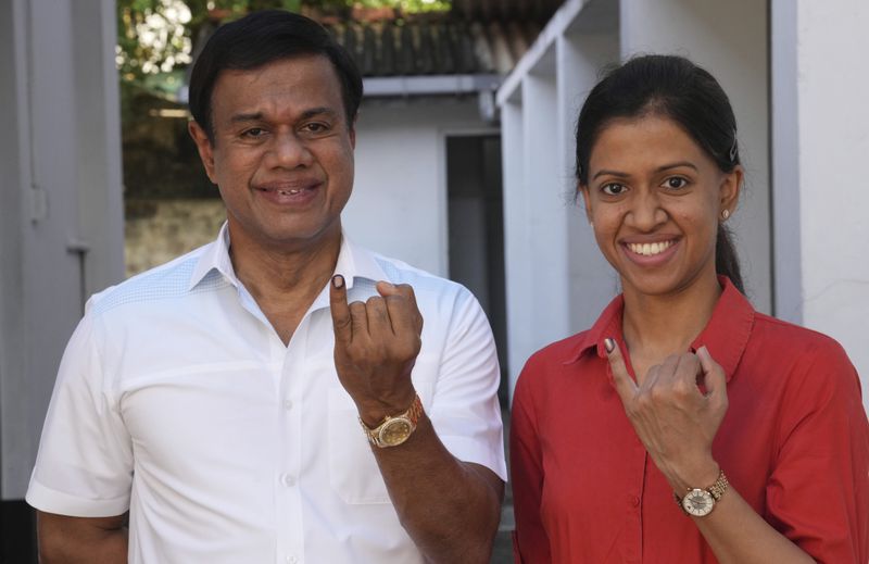 Sri Lankan show their index fingers marked with an indelible ink after casting their vote at a polling center for presidential election in Colombo, Sri Lanka, Saturday, Sept. 21, 2024. (AP Photo/Rajesh Kumar Singh)