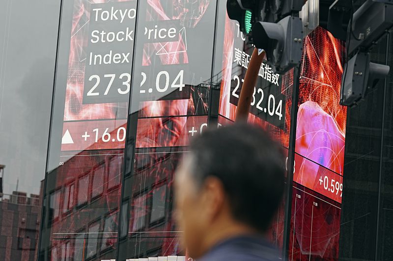 A person stands an electronic stock board showing Japan's Tokyo Stock Price index at a securities firm Tuesday, Sept. 3, 2024, in Tokyo. (AP Photo/Eugene Hoshiko)