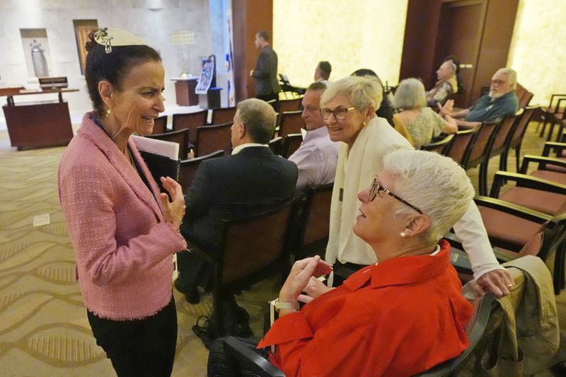 Gayle Pomerantz, left, senior rabbi at Temple Beth Sholom, chats with worshipers before the start of a Shabbat service, Friday, Sept. 27, 2024, in Miami Beach, Fla. (AP Photo/Wilfredo Lee)