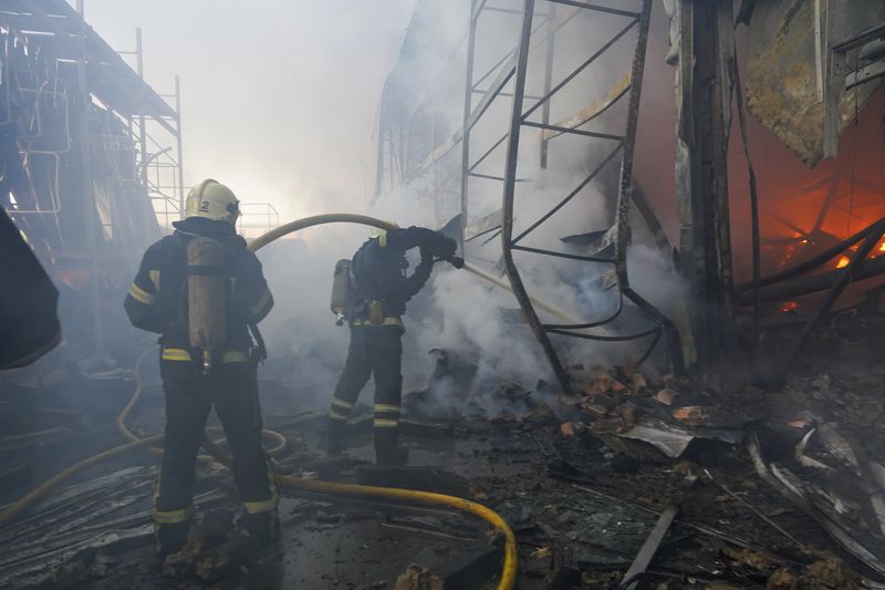 Firefighters put out a fire after two guided bombs hit a large construction supplies store in Kharkiv, Ukraine, Saturday, May, 25, 2024. (AP Photo/Andrii Marienko)