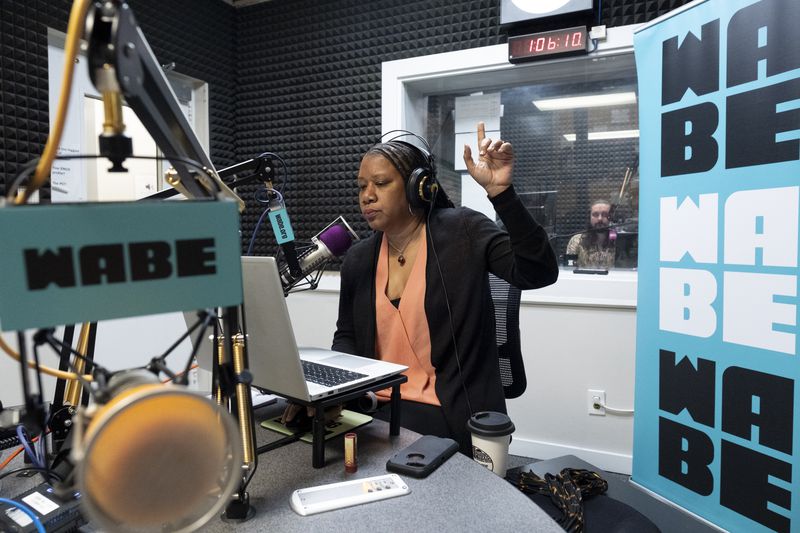 Rose Scott signals as "Closer Look" goes on air in the WABE studio in Atlanta on Monday, Sept. 18, 2023.   (Ben Gray / Ben@BenGray.com)