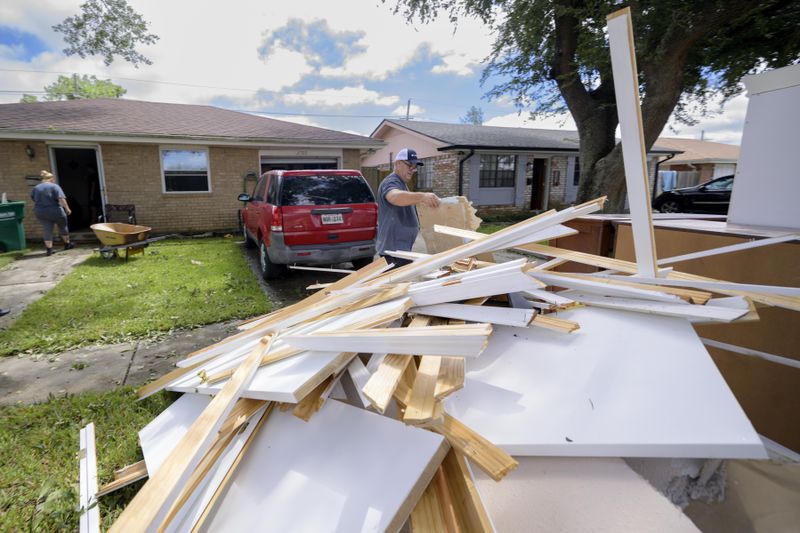 Shawn Murphy removes drywall at a friend's house after floodwater came up a few inches in the house making most of the walls, floors, and doors wet after Hurricane Francine in Kenner, La., in Jefferson Parish, Thursday, Sept. 12, 2024. (AP Photo/Matthew Hinton)