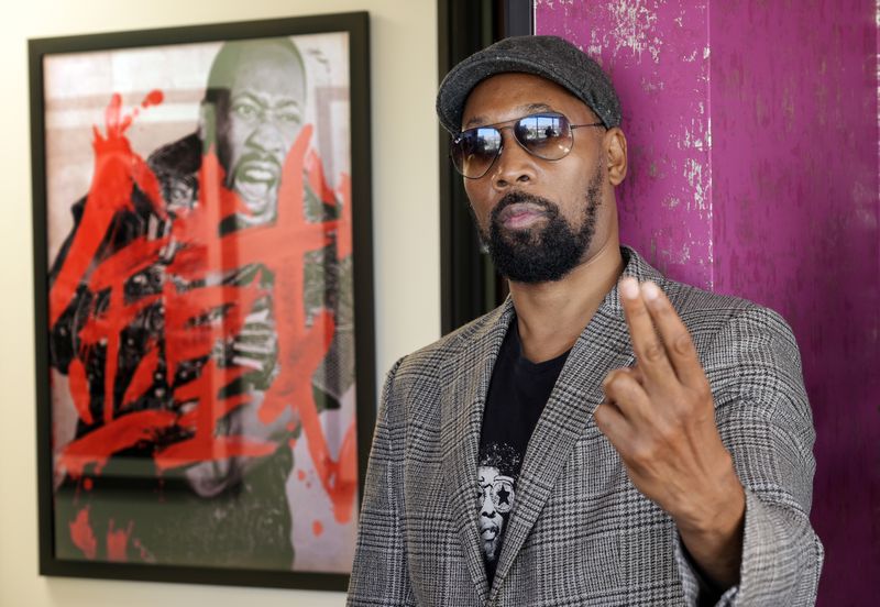 Musician, actor and filmmaker RZA poses for a portrait near a poster for his 2012 film "The Man with the Iron Fists" at his office, Wednesday, Aug. 28, 2024, in Los Angeles. (AP Photo/Chris Pizzello)