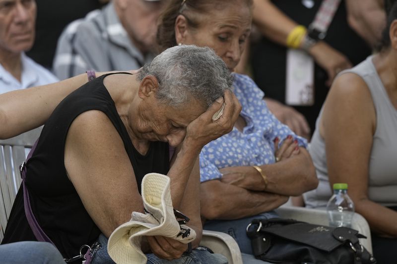 Tami Metzger mourns during the funeral of her husband Yoram Metzger at a cemetery of the kibbutz Nir Oz, southern Israel, Thursday, Aug. 22, 2024. Metzger's body was one the six bodies of hostages, taken in Hamas' Oct. 7 attack, recovered by Israel's military during an operation in the Gaza Strip. (AP Photo/Tsafrir Abayov)