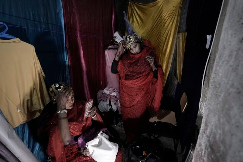 Sudanese Camirata troupe dancers Hoda Othman, right, and Amal Soliman put makeup on before their show at the Russian culture center in Cairo, Egypt, Sunday, Sept. 15, 2024. (AP Photo/Amr Nabil)