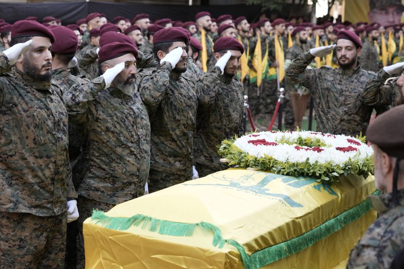 Hezbollah members salute near the coffin of Hezbollah commander Ibrahim Akil during the funeral procession in Beirut's southern suburb, Sunday, Sept. 22, 2024. (AP Photo/Bilal Hussein)