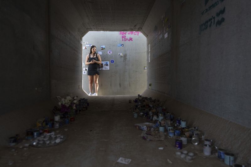 A woman stands next to a shelter at the site of the Tribe of Nova music festival, where at least 364 people were killed and abducted during the Hamas attack on Oct. 7, near Kibbutz Re'im on Thursday, June 20, 2024. A new kind of tourism has emerged in Israel in the months since Hamas’ Oct. 7 attack. For celebrities, politicians, influencers and others, no trip is complete without a somber visit to the devastated south that absorbed the brunt of the assault near the border with Gaza. (AP Photo/Ohad Zwigenberg)