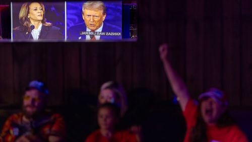 Tiana Robinson cheers at a Republican presidential debate watch party Tuesday at the Adventure Outdoors gun store and indoor shooting range in Smyrna. (Arvin Temkar / AJC)