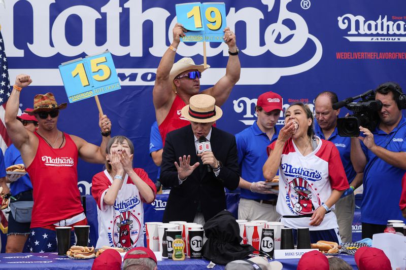 Miki Sudo, right, and Mayoi Ebihara, left, compete in the women's division of Nathan's Famous Fourth of July hot dog eating contest, Thursday, July 4, 2024, at Coney Island in the Brooklyn borough of New York. Sudo won by eating a record 51 hot dogs. (AP Photo/Julia Nikhinson)