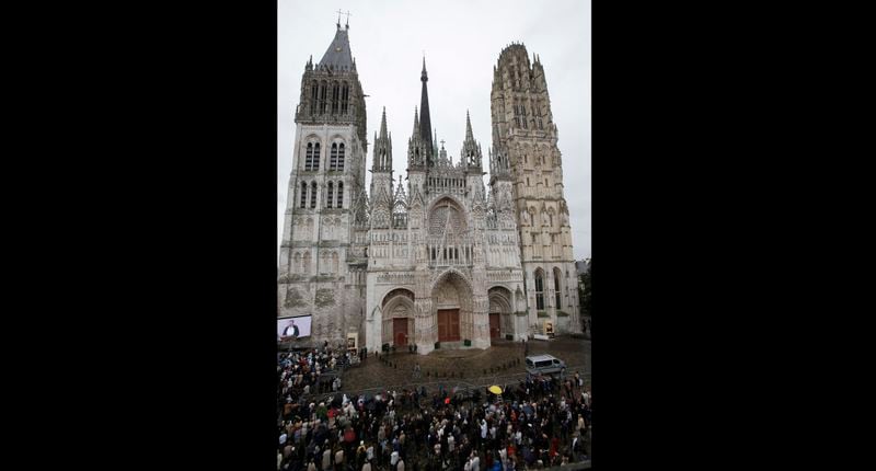 FILE - Crowd gather outside the Rouen Cathedral, in Normandy, France, during the funeral mass for Father Hamel, Tuesday, Aug. 2, 2016. French authorities on Thursday, July 11, 2024 say a fire has broken out on the spire of the medieval cathedral in the Normandy city of Rouen. Mayor Nicolas Mayer-Rossignol posted on social media that ‘’the beginning of a fire is underway on the spire of the cathedral of Rouen. The origin is unknown at this stage. (AP Photo/Michel Euler, File)