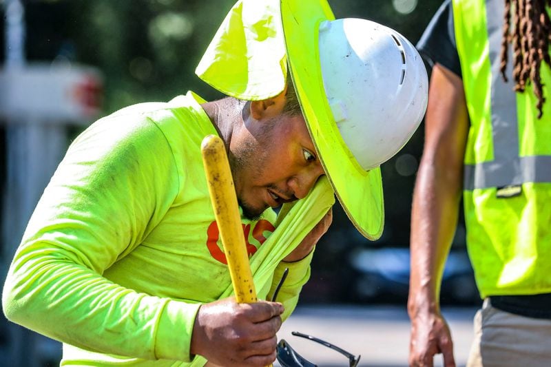 Fernando Rosales with RJH electrical contractors worked on installing an electrical box on Northside Drive near I-75 as he wiped away the sweat from the oppressive heat in metro Atlanta on Aug. 14, 2023. (John Spink/The Atlanta Journal-Constitution/TNS)