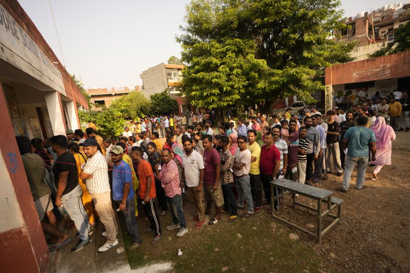 People queue up to cast their vote at a polling booth during the third phase of the Jammu and Kashmir Assembly election in Jammu, India, Tuesday, Oct. 1, 2024. (AP Photos/Channi Anand)