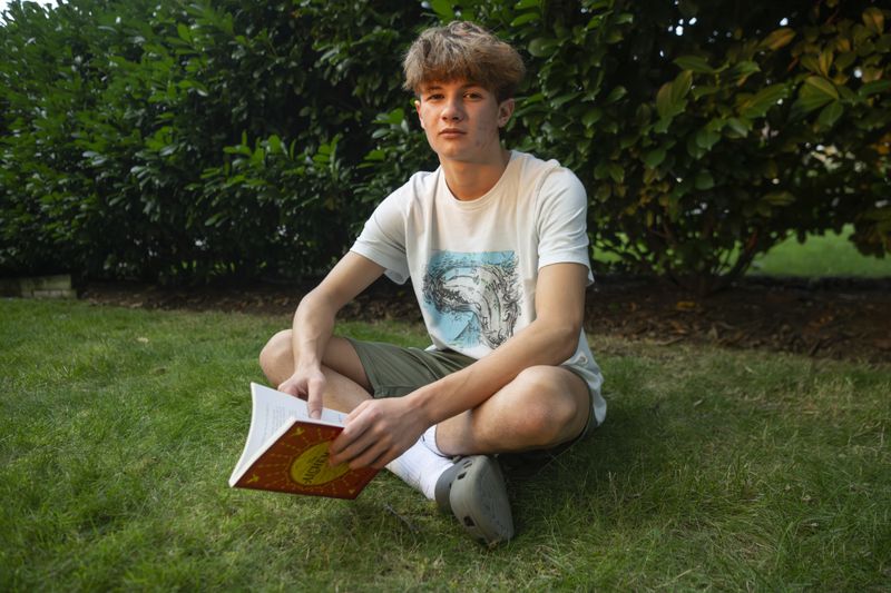 Chris Stanislawski, 14, poses for a portrait outside of his home in Garden City, N.Y., on Friday, Sept. 13, 2024. Chris didn't finish any books in his 8th grade English class, in part because their google classroom had detailed summaries of each chapter of every book. (AP Photo/Brittainy Newman)